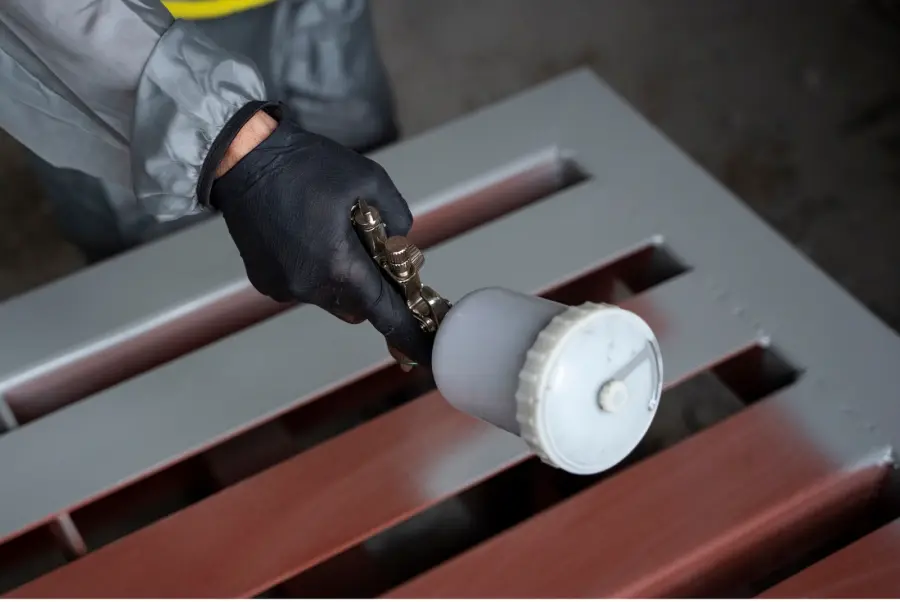 Industrial applicator spraying a protective coating onto a steel surface